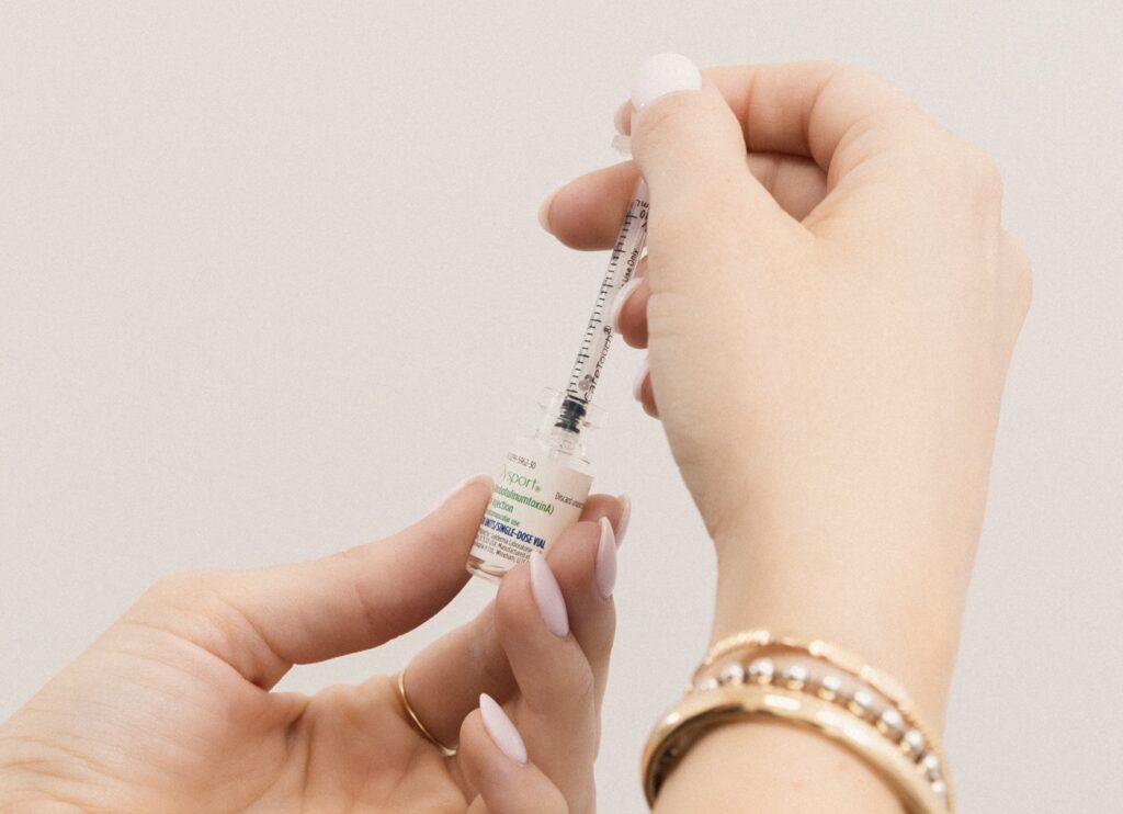 A provider's hands prepare a syringe with Dysport as they get ready to treat a client with Botox and filler in Georgetown.