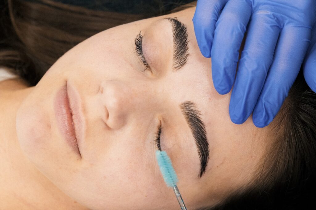 A close-up of a lash artist brushing a client's eyelashes before she applies eyelash extensions in Georgetown.